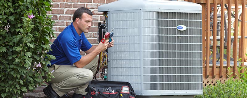 Carrier service tech checking gauges on ac unit